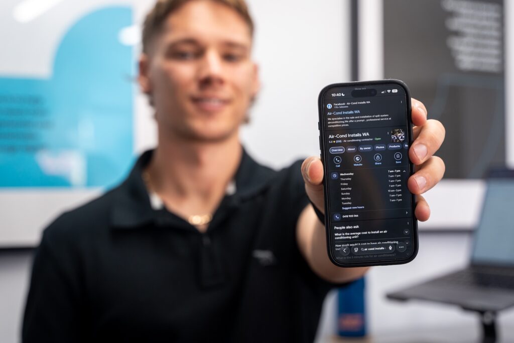 Man holding a phone displaying the Google Business Profile for Air-Cond Installs WA, demonstrating strong local SEO and map listing visibility in Perth.