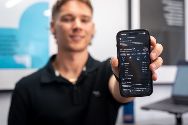 Man holding a phone displaying the Google Business Profile for Air-Cond Installs WA, demonstrating strong local SEO and map listing visibility in Perth.